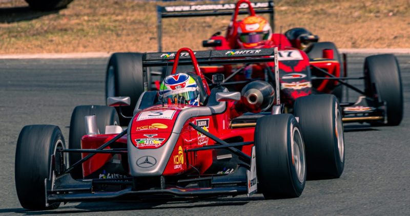 Car 3, Gilmour Racing being chased by car 17 in the background at Queensland Raceway during a formula 3 race