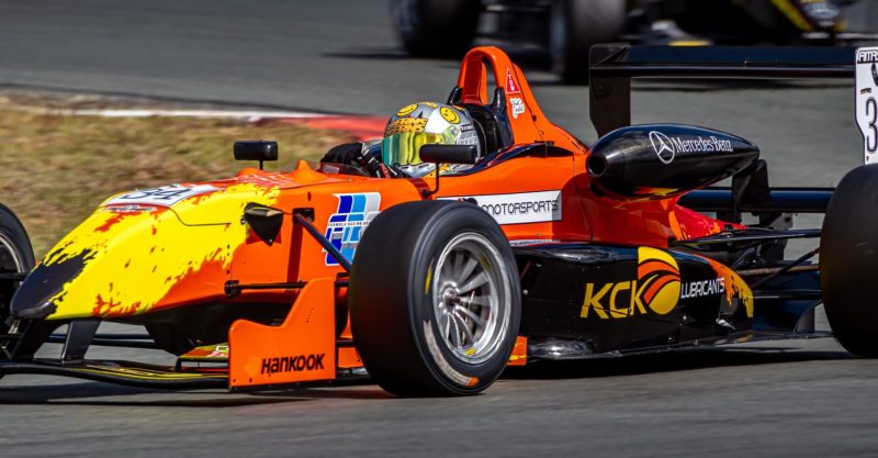 The bright orange and yellow of Car 34 comes away from corner at Queensland Raceway